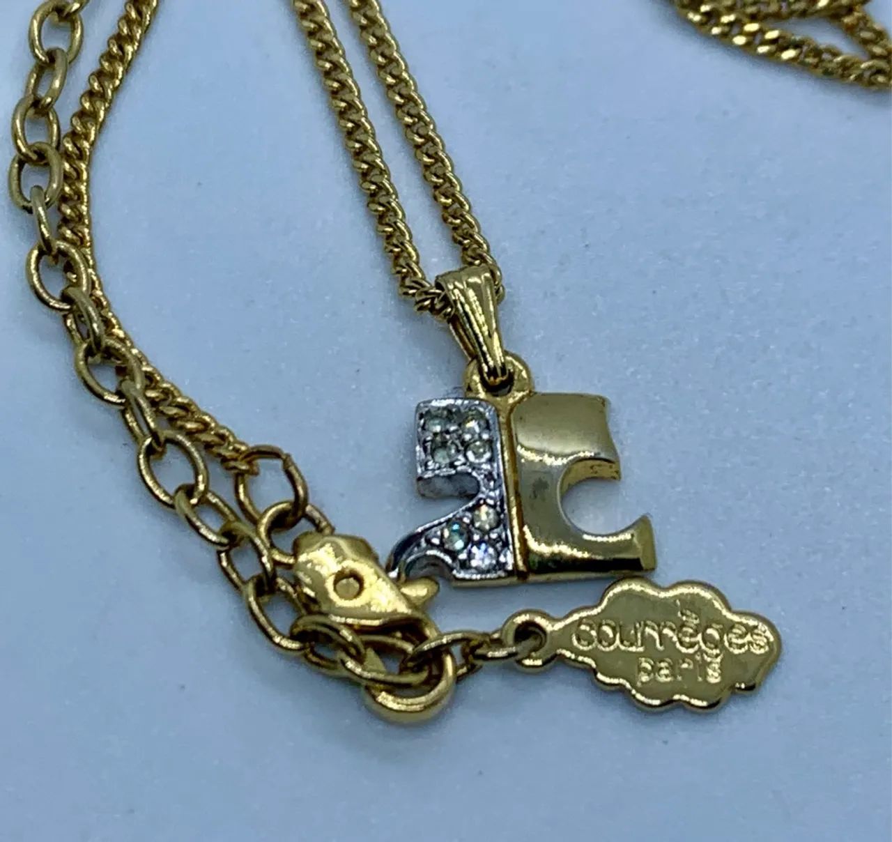 colar courreges logo dourado e pedras