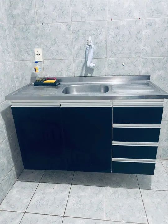 Armário de cozinha preto com 4 gavetas projetado. já com a pia
