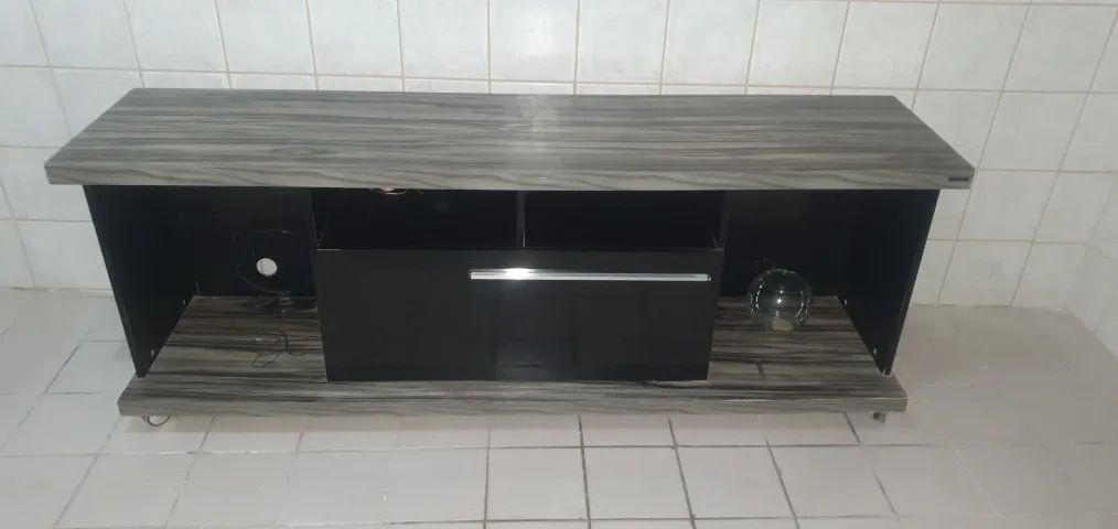 Rack de TV cinza e preto com gaveta e rodízios