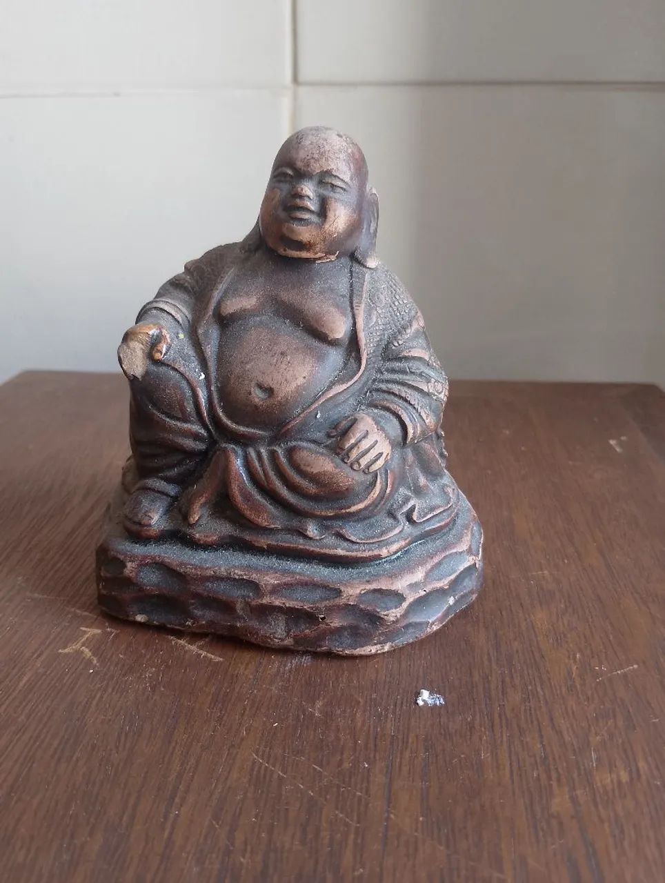 Buda sentado com avaria em uma das mãos 