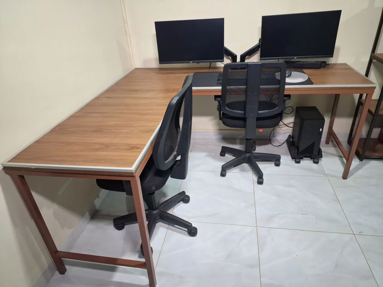 Computador 2 telas, cadeiras e mesa grande.