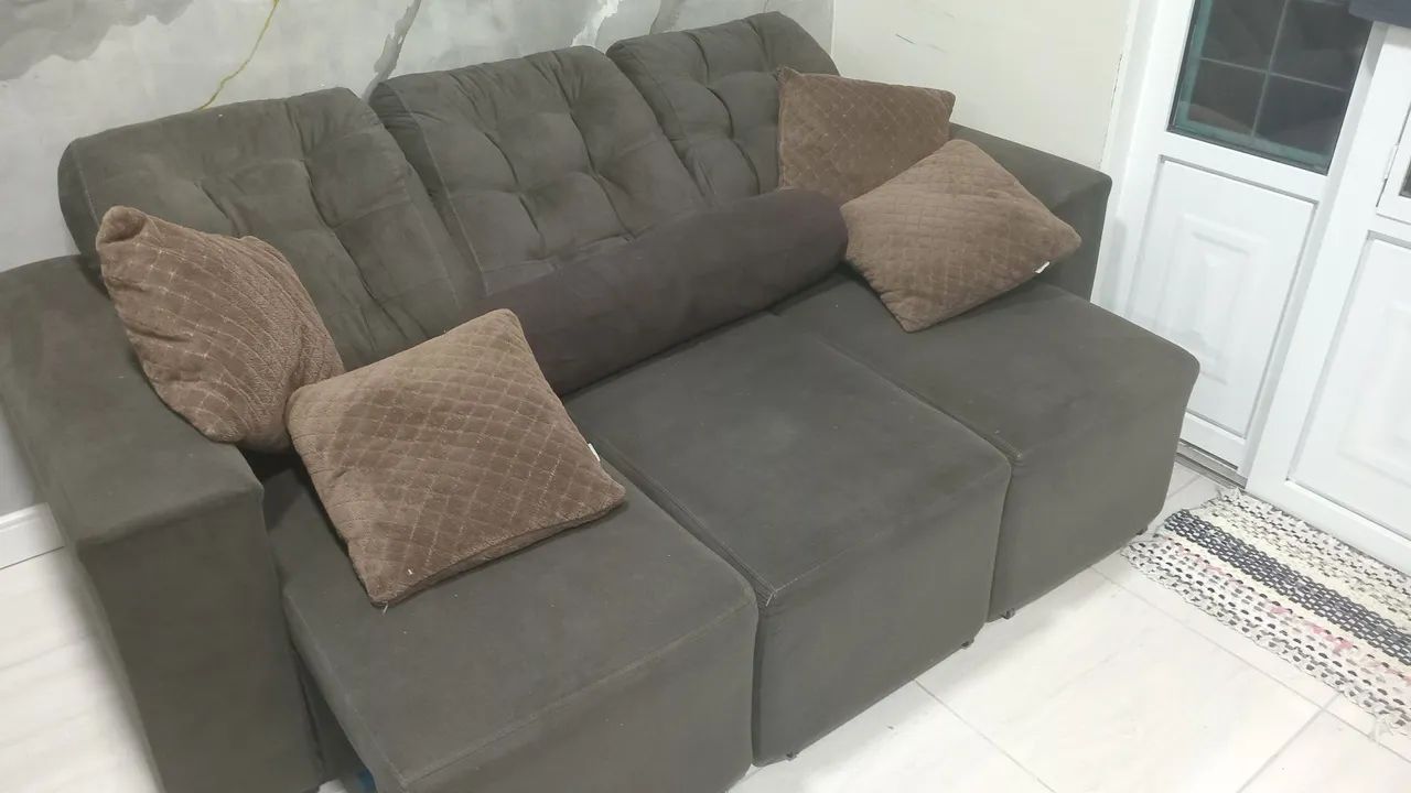 Vendo um sofá retrátil e uma geladeira. 
