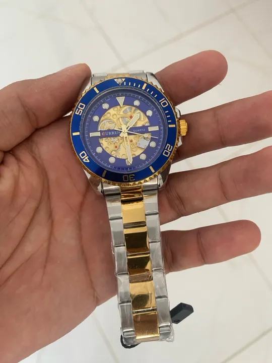 Relógio prata com detalhes dourados