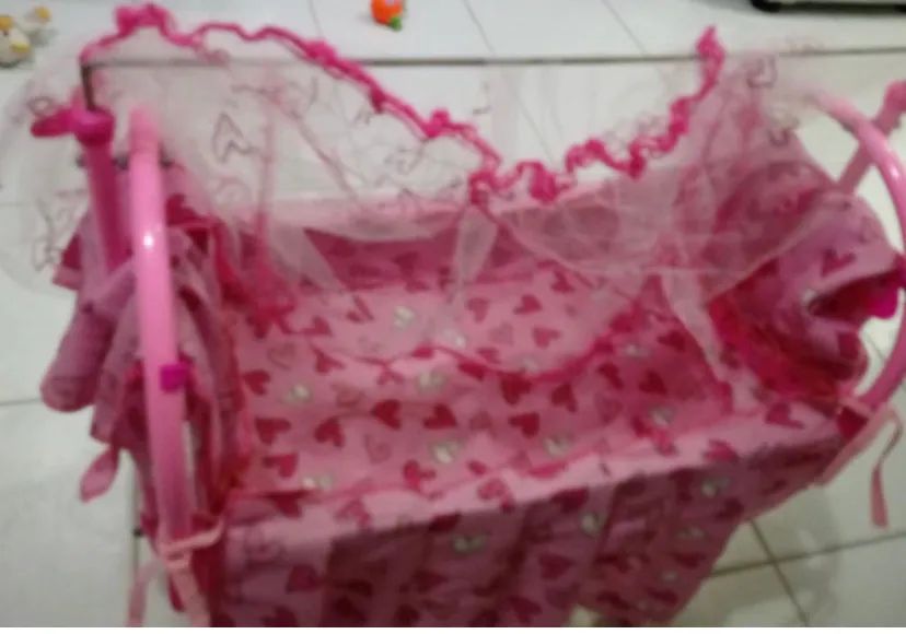 Berço de boneca rosa com mosquiteiro