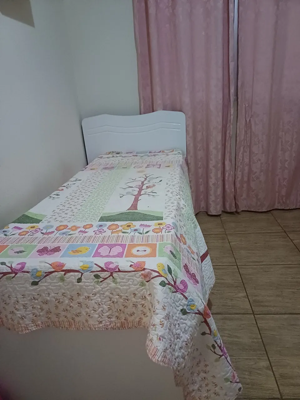 Cama de solteiro com colcha floral