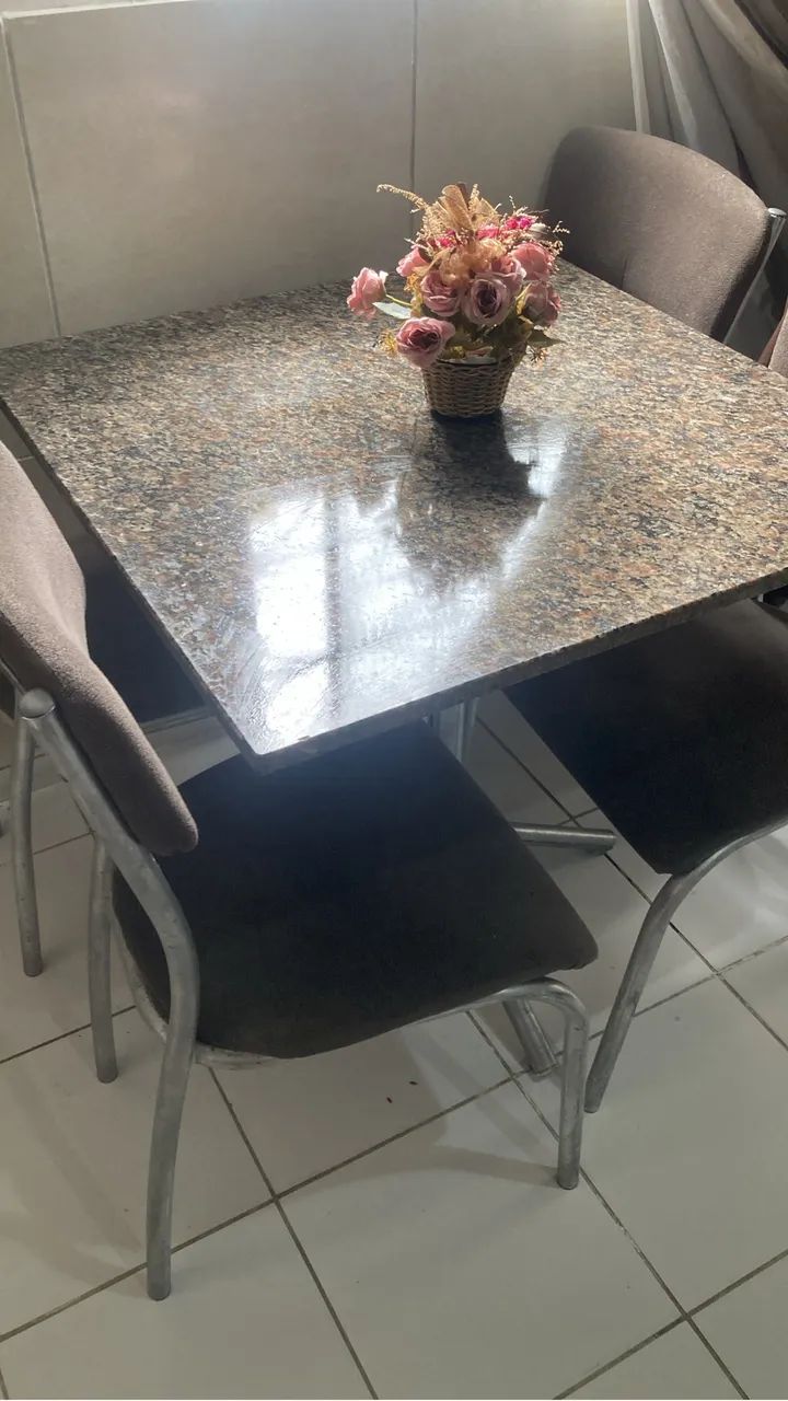 Mesa de mármore acompanhada de 4 cadeiras.