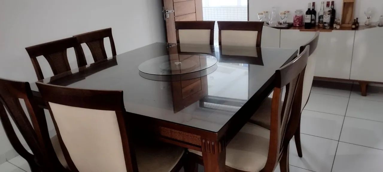 Mesa com tampo de vidro em madeira com 8 cadeiras acochoadas