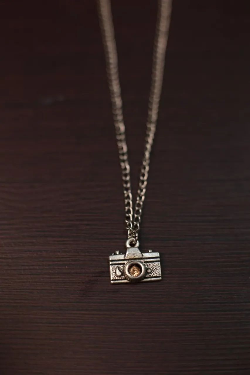 Colar com pingente de câmera e strass dourado 