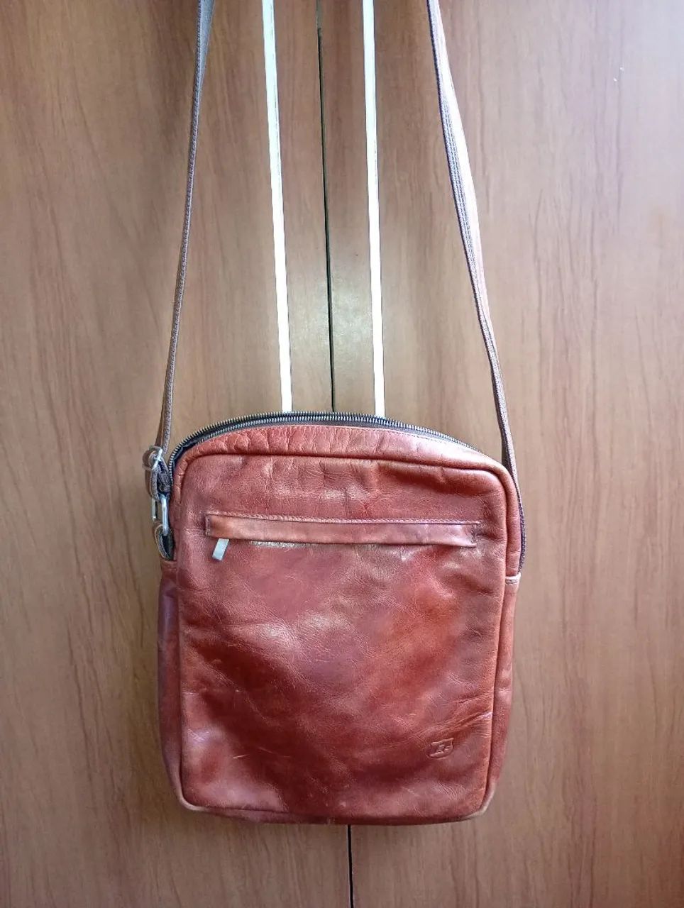 Bolsa lateral em couro legítimo.