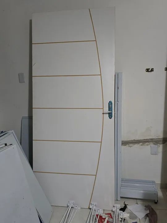 Porta branca de madeira com detalhes em dourado