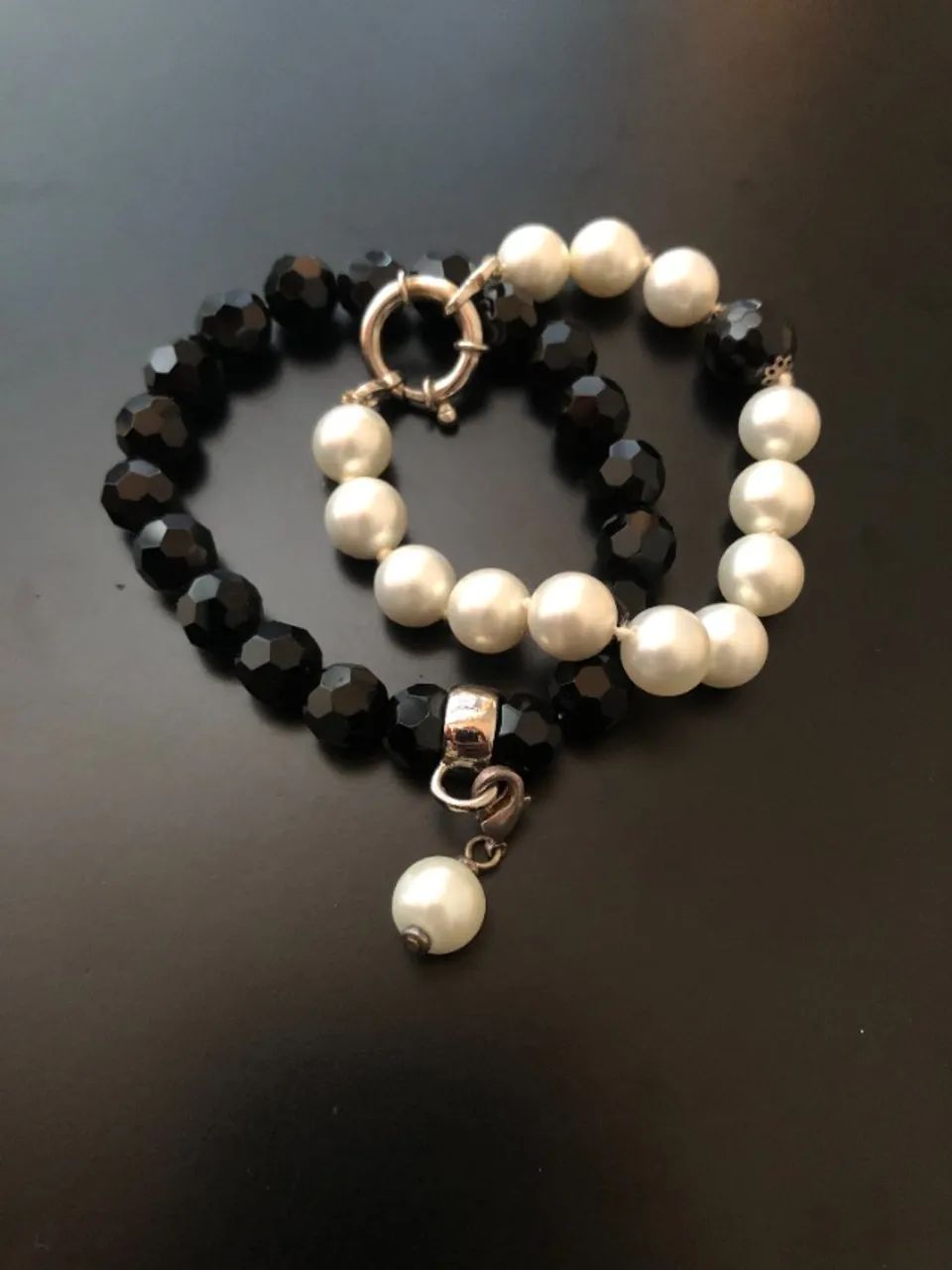 Preto e branco, pérola e facetado. Duas pulseiras, um clássico que não erra.