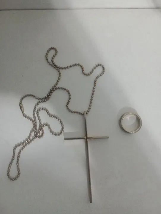 Cordão  com cruz , acompanha um anel .