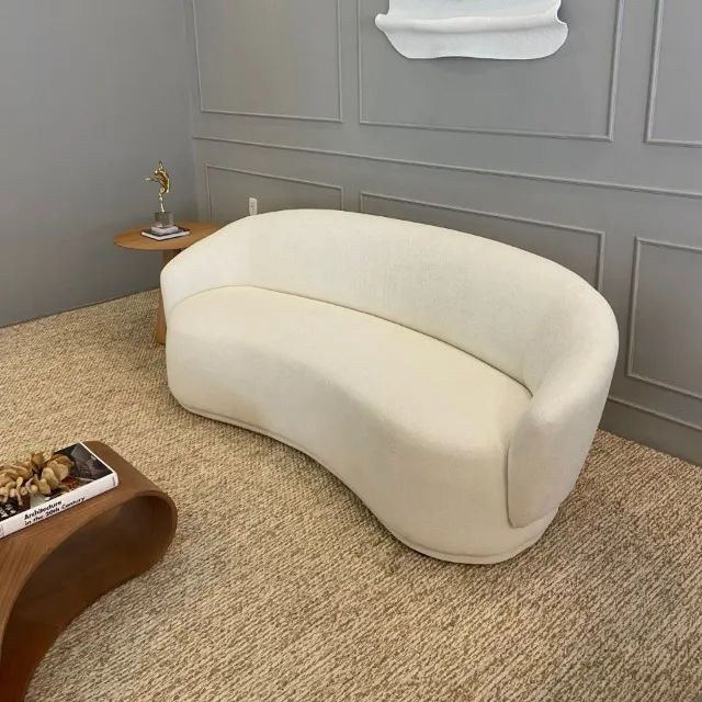 Sofá curvo em tecido bouclé laranja, design moderno e aconchegante. Perfeito para compor a