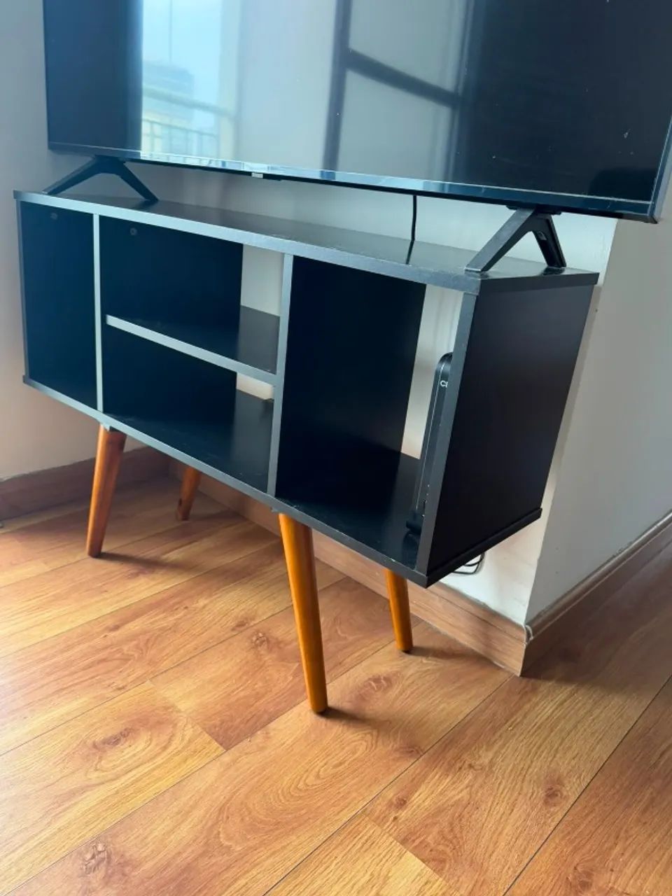 Rack para TV preto com pés de madeira