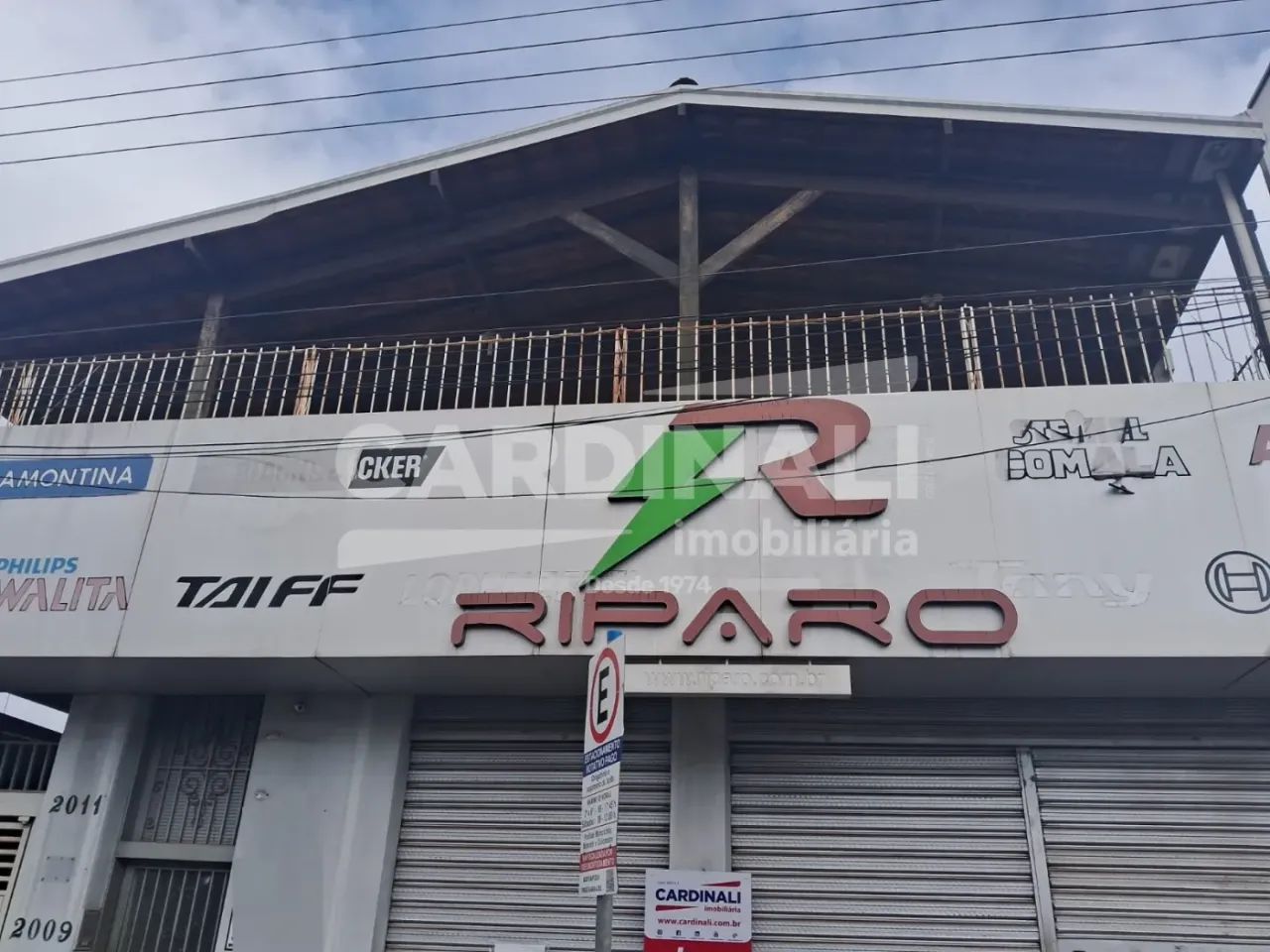 Salão no centro da cidade, com uma casa grande no piso superior.
