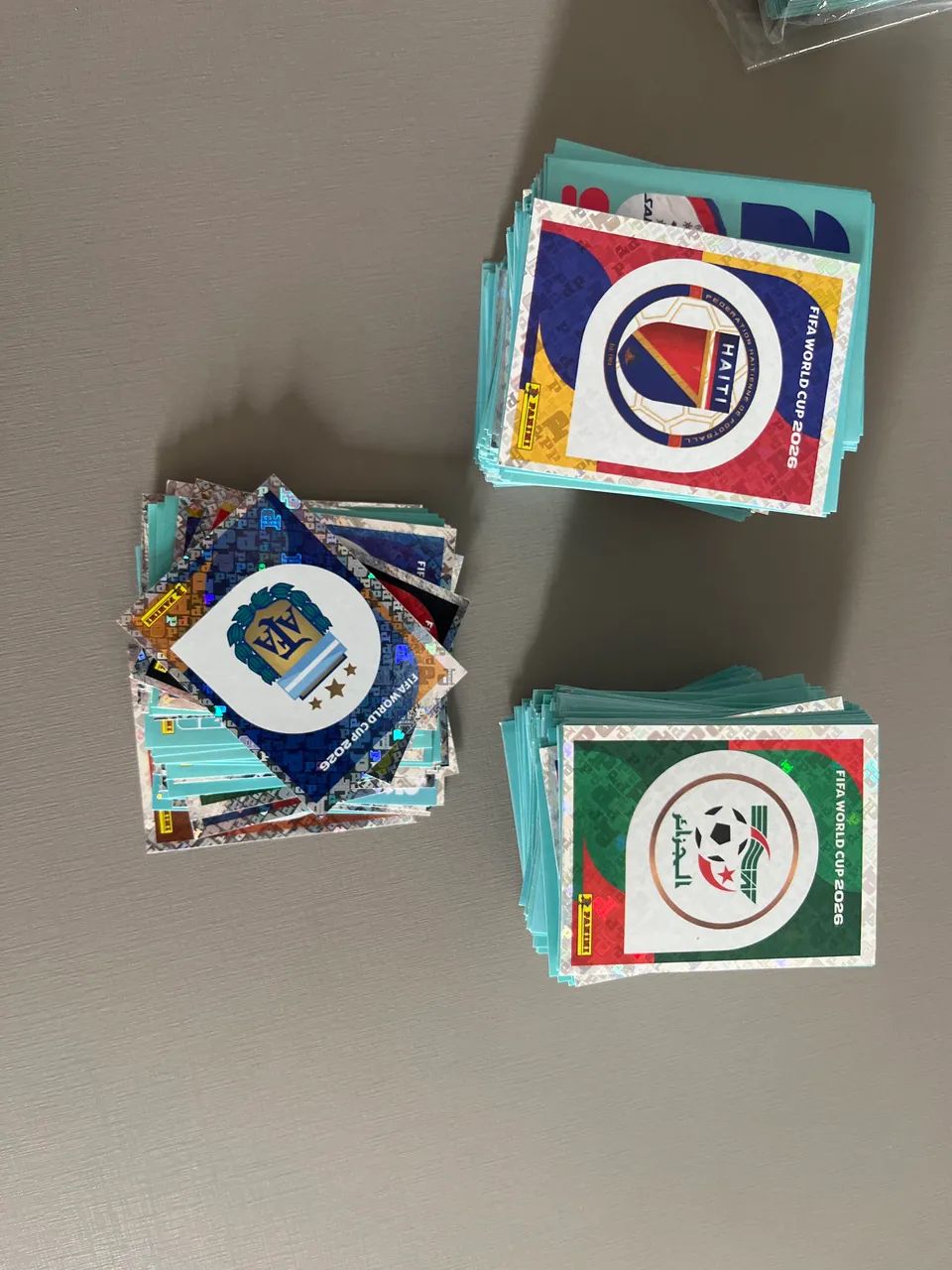 Figurinhas da Copa - 720 total e 460 sem repetição). Escudos e (Mbappe, CR7, Vini)
