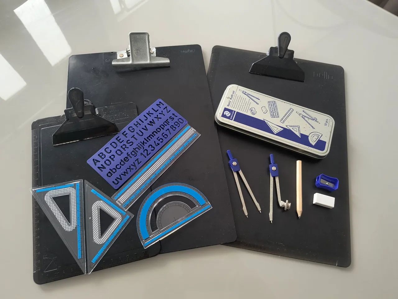 Pranchetas, esquadros e compasso 