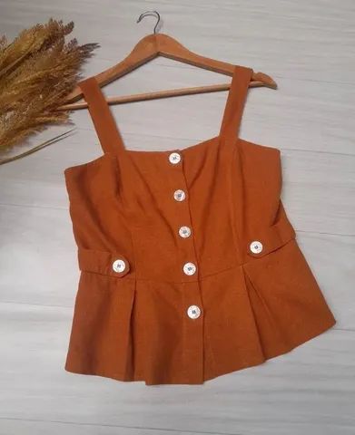 Cropped de linho na cor marrom, alça larga e botões da TOLI. <br>