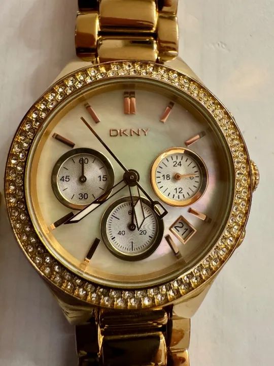 Relógio feminino DKNY em aço inox rose c mostrador envolto em cristais, fundo madrepérola
