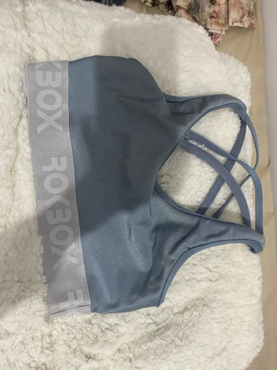 Top esportivo azul com detalhes em cinza