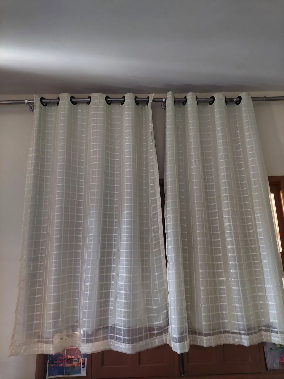 Cortinas amarelo claro com detalhes em grade