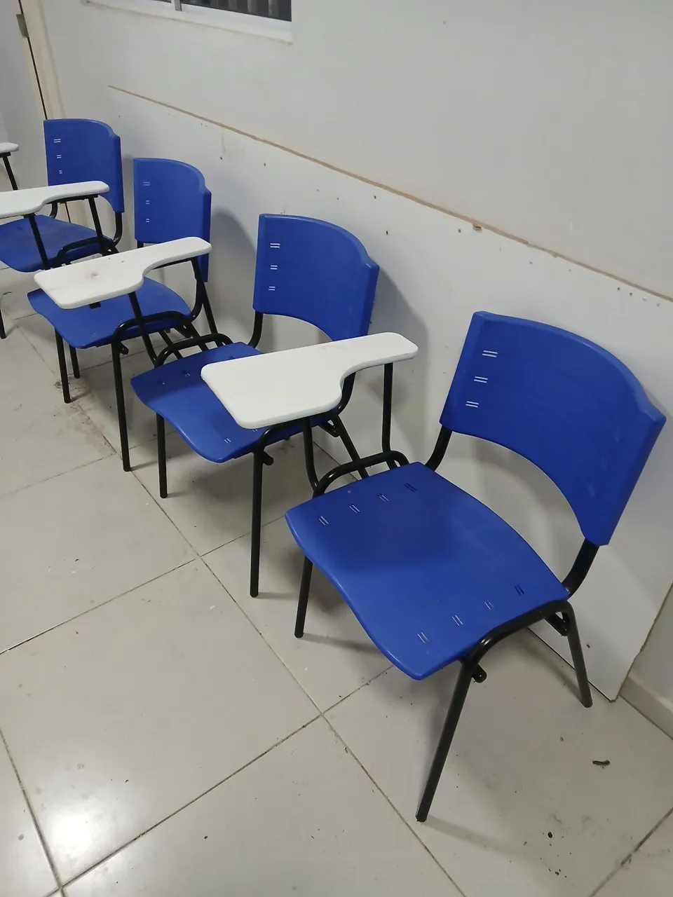 Cadeiras universitárias azuis com prancheta