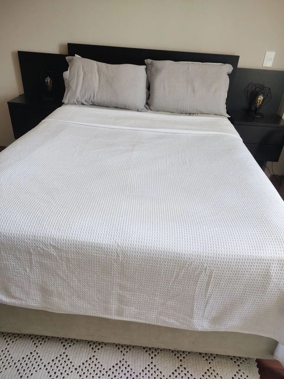 Cabeceira de cama preta com mesas de apoio embutidas