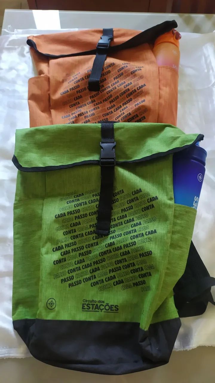 Duas mochilas corrida das estações verde e laranja e garrafas 