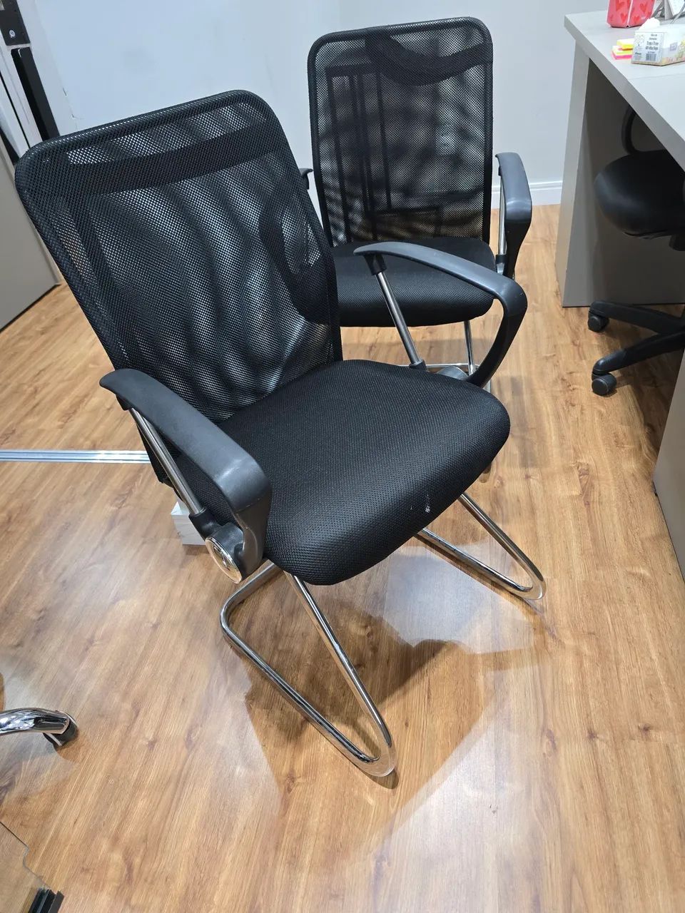 Uma cadeira giratório secretaria e duas cadeiras de recepção. Pretas de tecido e metal.