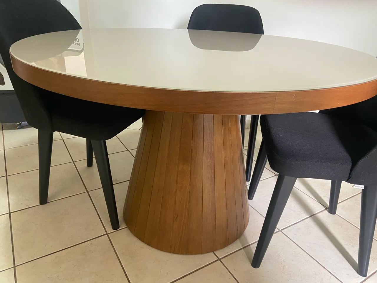 Mesa de jantar redonda com tampo de vidro e pés torneados