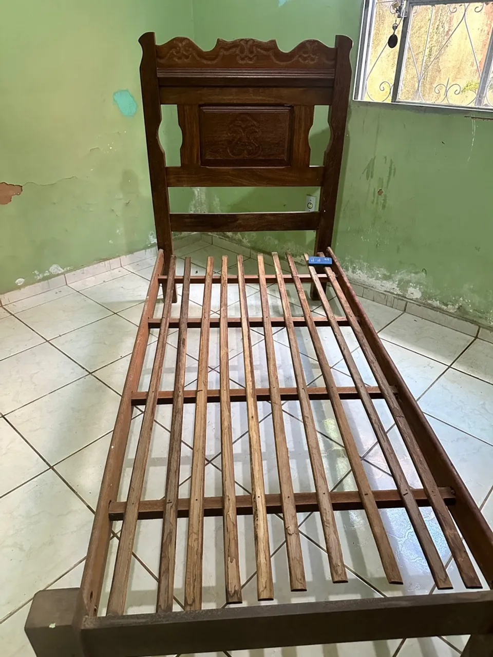 Cama de madeira antiga com detalhes entalhados