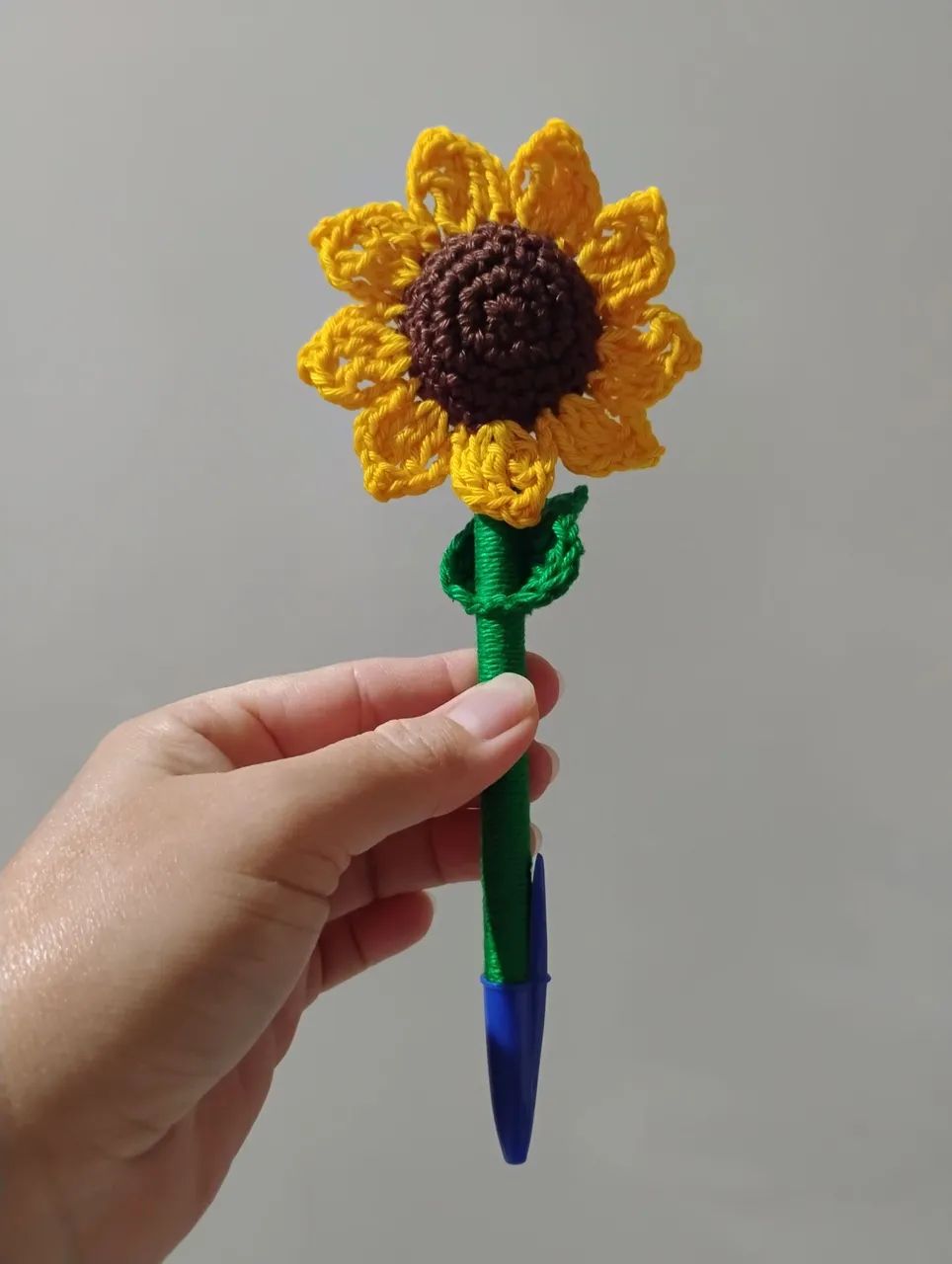 Caneta decorada com flor de girassol em crochê 