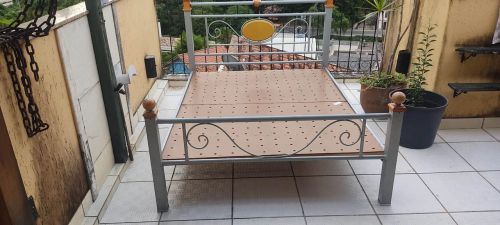 Cama de ferro com detalhes em madeira