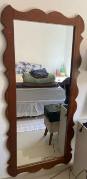 Espelho com moldura de madeira maciça.