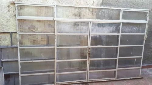 Duas janelas sem o vidro toda reformada e pintada de  cinza.