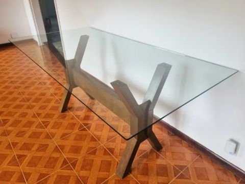 Mesa de jantar com tampo de vidro retangular.