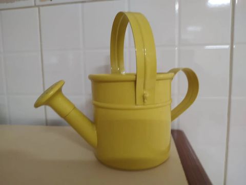 Regador de metal amarelo para decoração