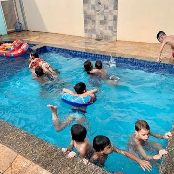 Área de festa com piscina aquecida e casa de temporada