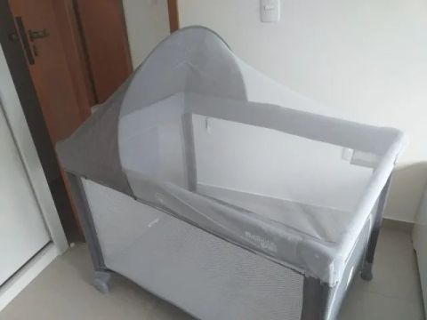 Berço desmontável com trocador, mosqueteiro e brinquedos