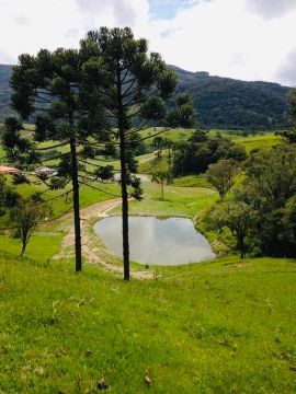 Sítio com açude, cachoeira e área verde em região montanhosa