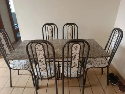 Mesa de mármore com 6 cadeiras.