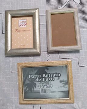 Três porta retratos, um em madeira clara com friso dourado, 1 bege claro com friso doura