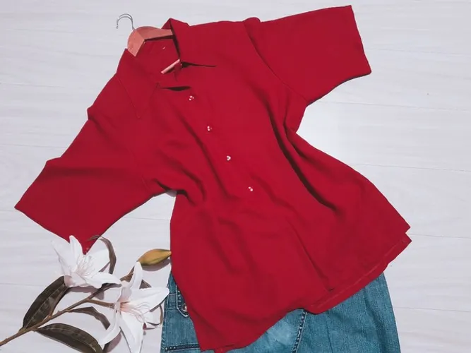 Blusa feminina em crepe, manga curta com ombreira e botões na frente.<br>