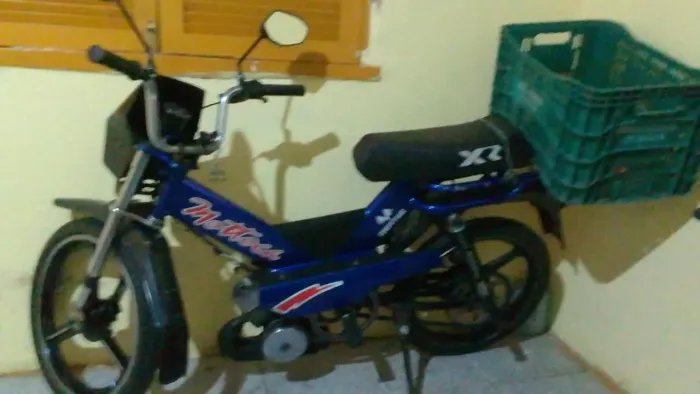 Mobilete na corrente, freio no pé, roda de moto.