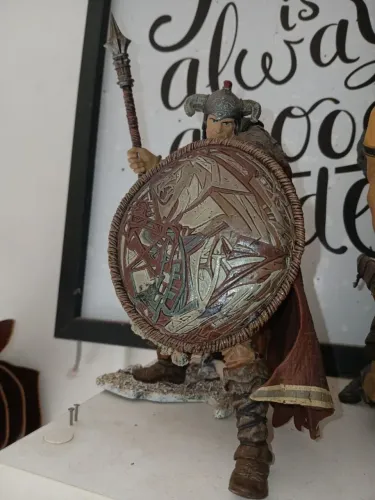 Um boneco do CONAN e um dragão da coleção da McFarlane Toys.