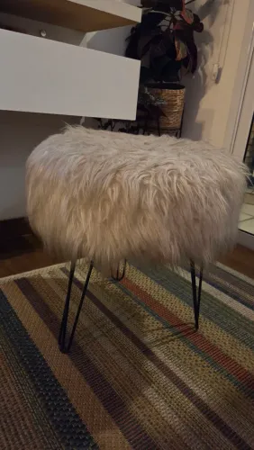 Puff redondo tipo banqueta revestida em pelúcia com pés de ferro