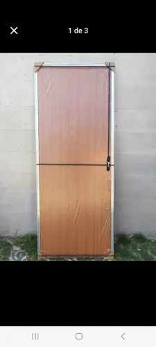 Porta de madeira lisa com marco em alumínio e fechadura.