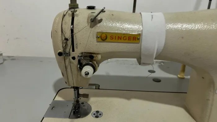 Máquina reta industrial costura funcionando. singer