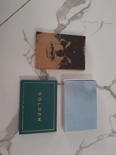 Álbuns solo BTS (Weverse ver.): V (Layover), Jung Kook (GOLDEN) e Jimin (FACE).