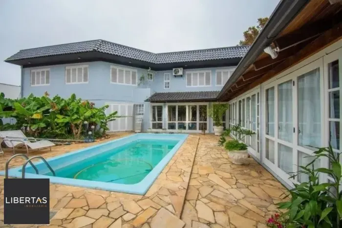 Casa com 3 dormitórios, suíte e amplo pátio com piscina e churrasqueira.